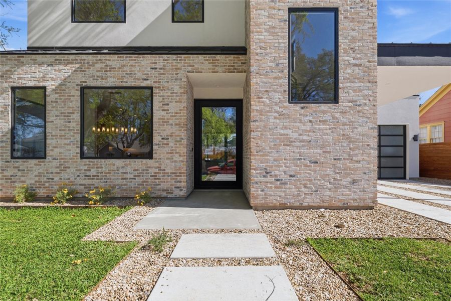 View of exterior entry featuring brick siding