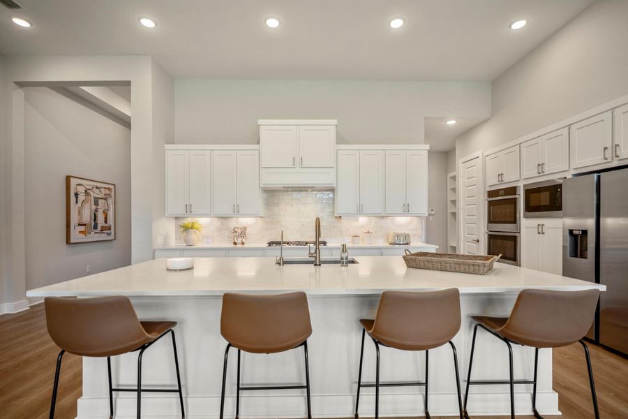 The oversized island is a natural gathering hub, with bar seating and plenty of room to sip morning coffee, enjoy a late-night snack and share everyday moments in between.