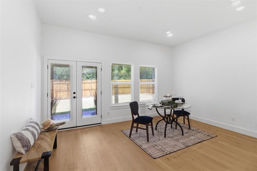 Dining area featuring light wood-finish flooring, recessed ceiling lighting, and a white baseboard trim