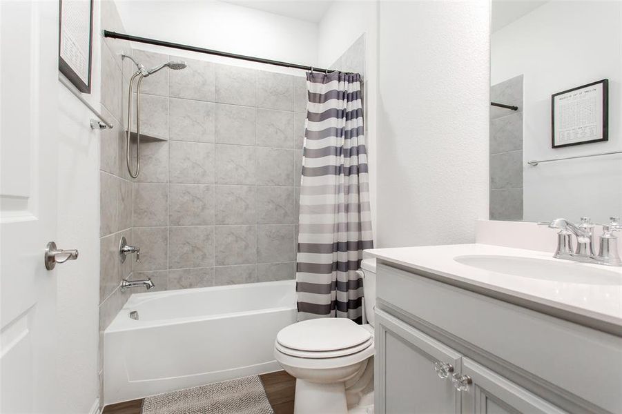 Full bathroom with vanity, wood finished floors, and shower / bath combo