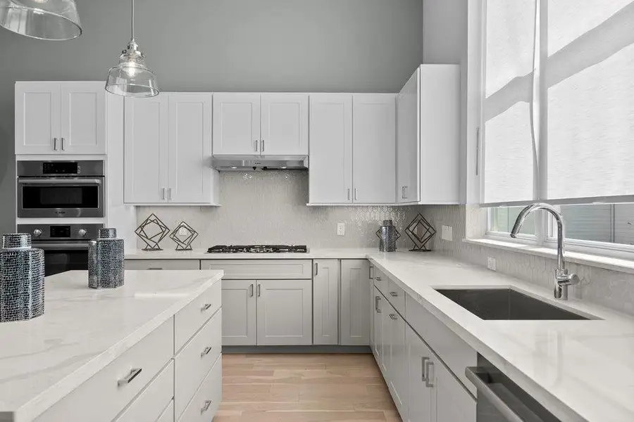 High ceilings and gleaming stone countertops elevate this contemporary kitchen design. High ceilings and gleaming stone countertops elevate this contemporary kitchen design.