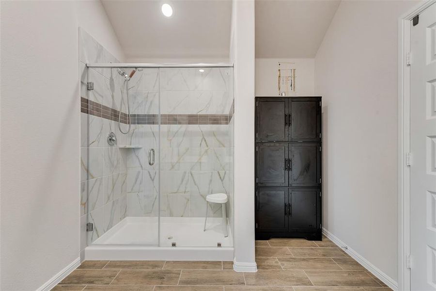 Bathroom featuring a shower stall, wood finish floors, recessed lighting, and lofted ceiling Bathroom featuring a shower stall, wood finish floors, recessed lighting, and lofted ceiling