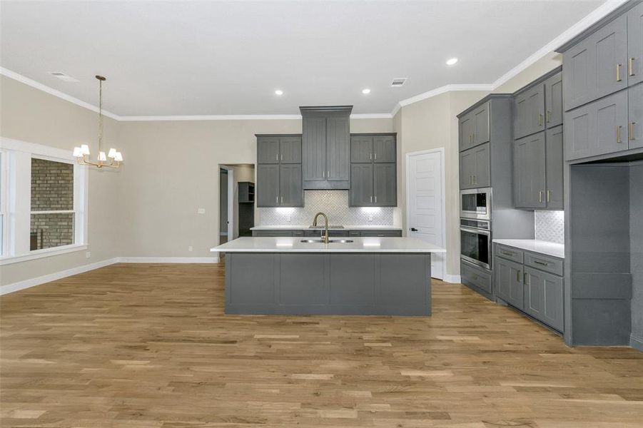 Kitchen featuring gray cabinets, sink, light wood-type flooring, and appliances with stainless steel finishes