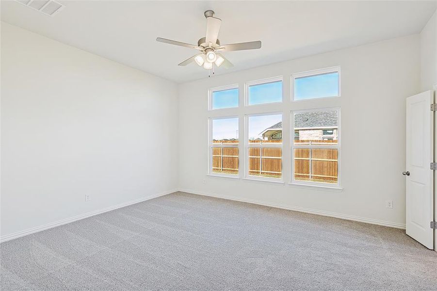 Carpeted empty room featuring ceiling fan