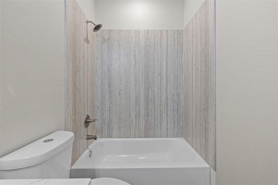 Bathroom with toilet and tiled shower / bath