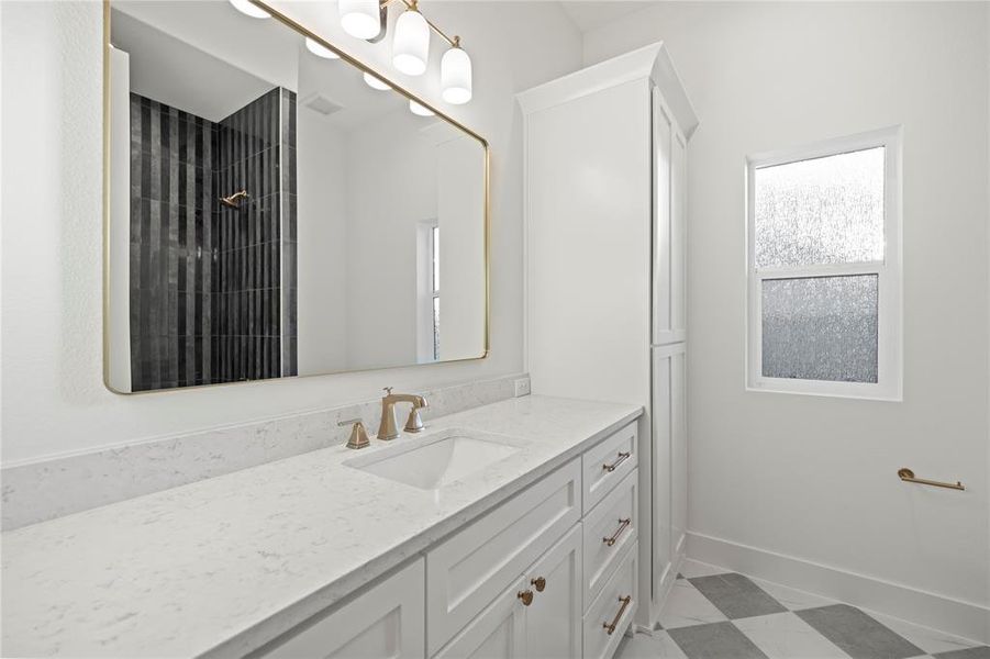 Dual-sink vanity featuring a white countertop, under-mount sinks, and brass-finish fixtures