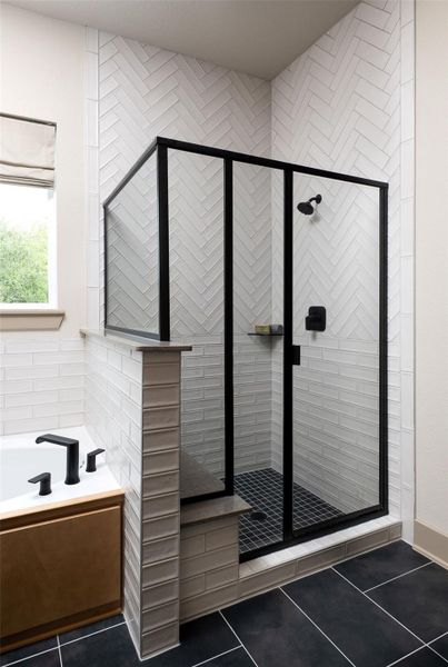 This additional view of your primary bathroom features tile flooring, fresh paint, walk-in shower, a separate garden tub, and a large walk-in closet.