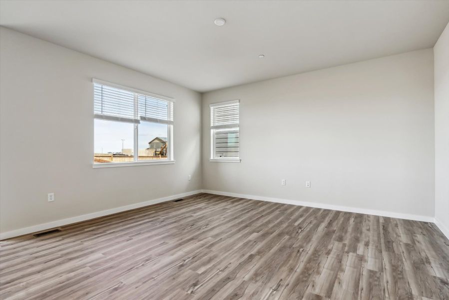 A room with a wood floor and a wood floor with a window.