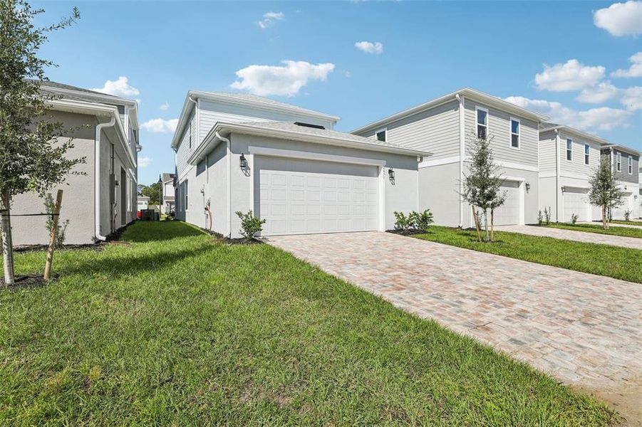 Front exterior of a new home in Trinity Place, St. Cloud, FL, highlighting curb appeal (Image 2). Front exterior of a new home in Trinity Place, St. Cloud, FL, highlighting curb appeal (Image 2).