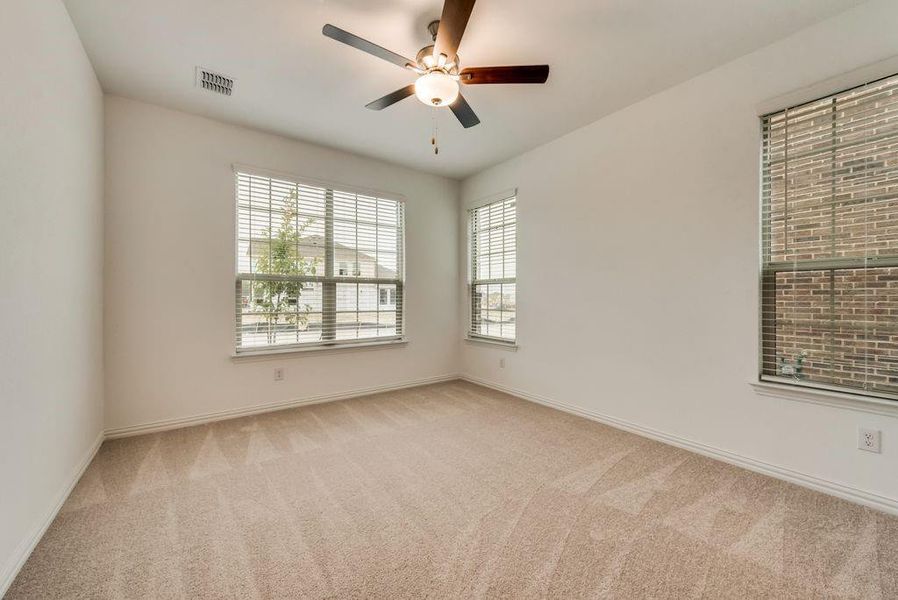 Spare room featuring light colored carpet and ceiling fan