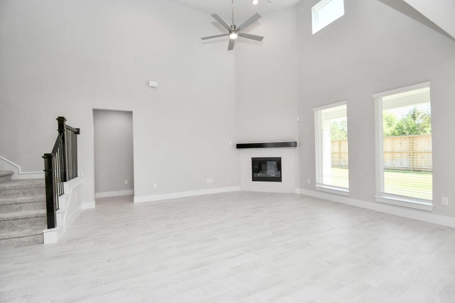 Gather the family and guests together in your lovely living room! Featuring soaring high ceilings, recessed lighting, ceiling fan, custom paint, gorgeous floors, and large windows that provide plenty of natural lighting throughout the day. Sample photo of completed home with similar floor plan. Actual colors and selections may vary.