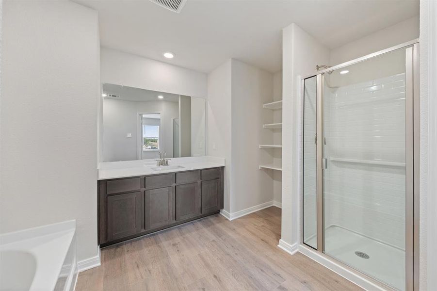 Bathroom with vanity, wood finished floors, a stall shower, and recessed lighting