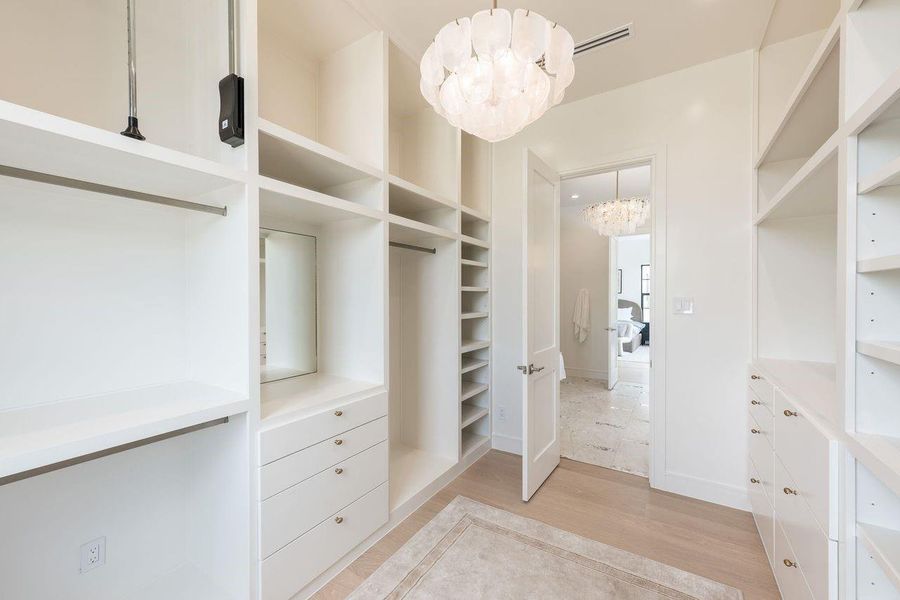 Designed with intention and impeccable organization, this expansive walk-in closet features open shelving, integrated drawers, and dedicated shoe displays. Warm wood tones and a built-in bench transform daily routines into a refined experience.