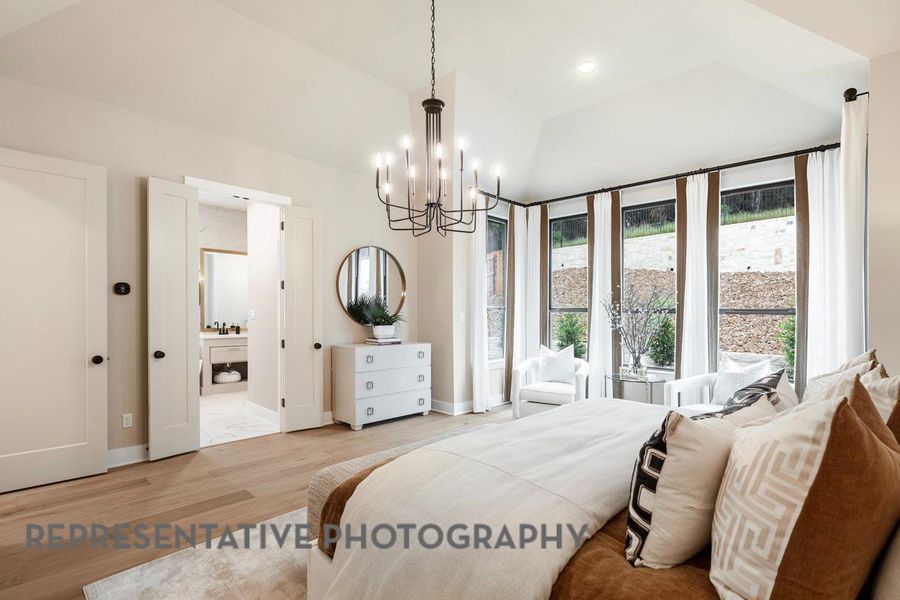 Bedroom with wood finished floors, a chandelier, baseboards, and ensuite bathroom Bedroom with wood finished floors, a chandelier, baseboards, and ensuite bathroom