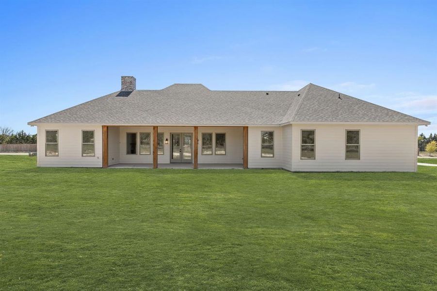 Rear view of house with a patio and a yard