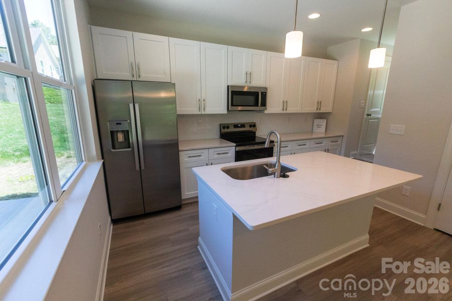 Breakfast bar with Pendant lights over island add style