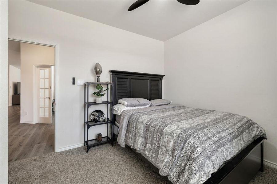 Carpeted bedroom featuring a ceiling fan and lofted ceiling Carpeted bedroom featuring a ceiling fan and lofted ceiling