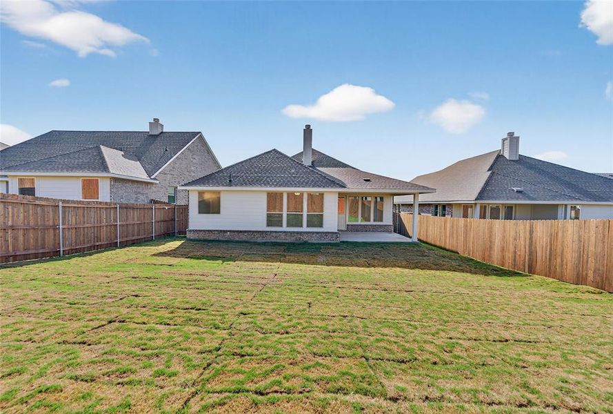 Rear view of property with a patio, a fenced backyard, a shingled roof, and a chimney
