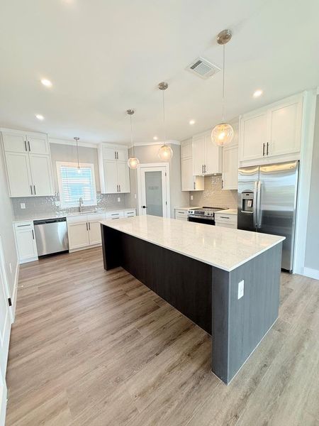 Culinary dreams come alive in this kitchen featuring an expansive island and gleaming stainless steel appliances.