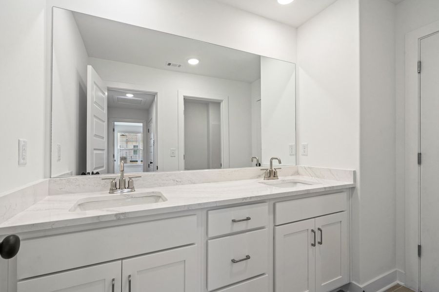 Dual vanity featuring a white countertop with integrated sinks and brushed nickel faucets