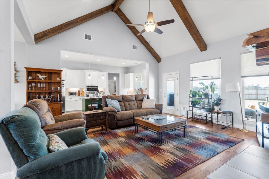 Living area with dark wood-style flooring, ceiling fan, vaulted ceiling, and recessed lighting