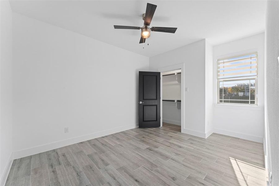 Unfurnished bedroom featuring ceiling fan, light hardwood / wood-style floors, and a closet