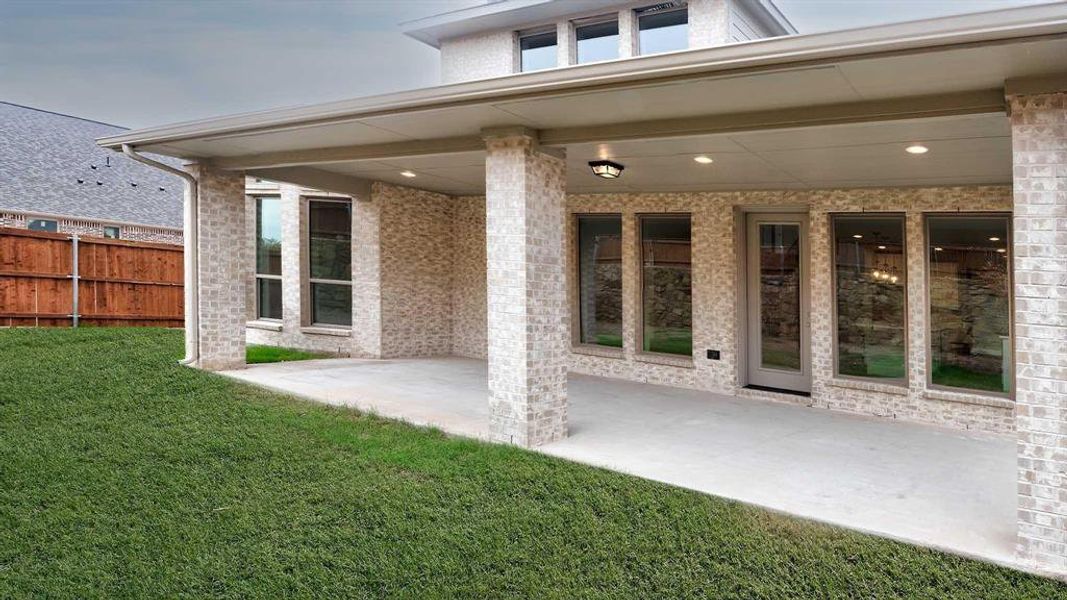 Rear view of property with a patio and a lawn