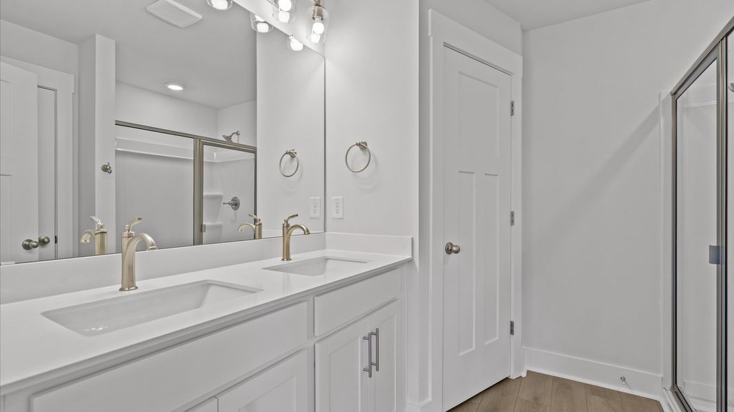 Highly functional and elegant en-suite with dual vanities, walk-in shower, and refined finishes