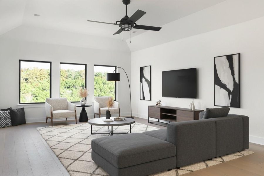 Spacious room with light wood-finish flooring and vaulted ceilings