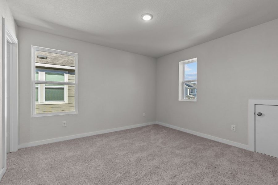 A room with a carpet and windows.