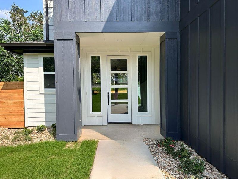 A striking modern facade features a contrasting board-and-batten and horizontal siding entrance with a welcoming pathway. A striking modern facade features a contrasting board-and-batten and horizontal siding entrance with a welcoming pathway.