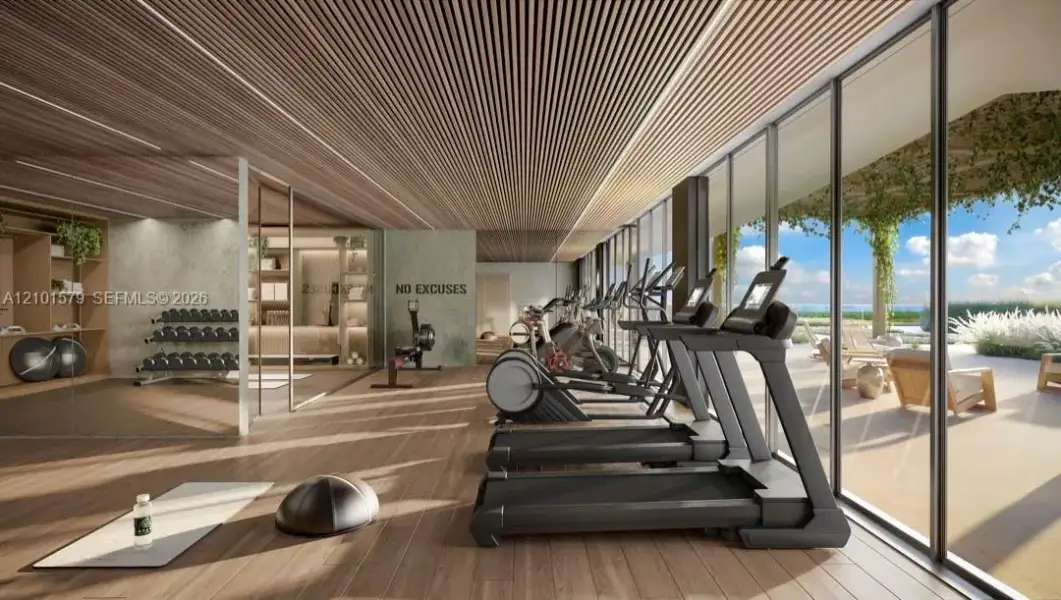 Fitness facility featuring wood-slat ceiling, full-height glass walls, wood-finish flooring, and built-in shelving
