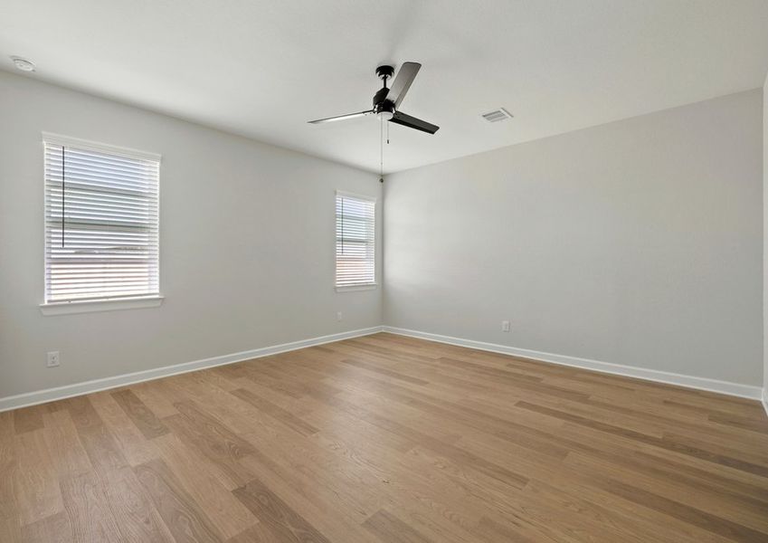 Master bedroom with two windows and ceiling fan light fixture