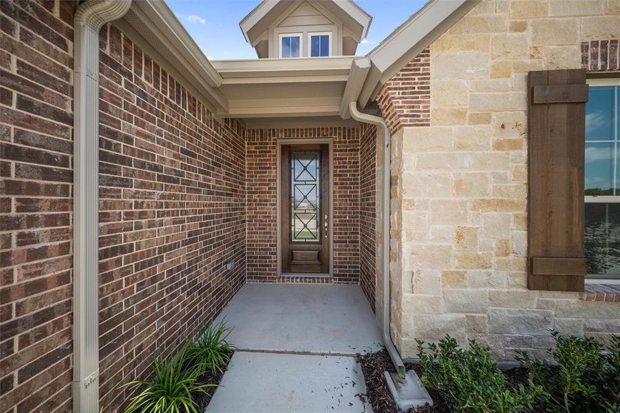 View of exterior entry featuring brick siding