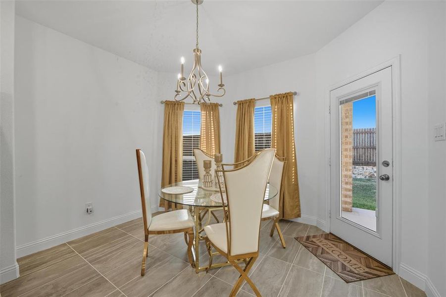 Dining space with a chandelier and light tile patterned floors Dining space with a chandelier and light tile patterned floors