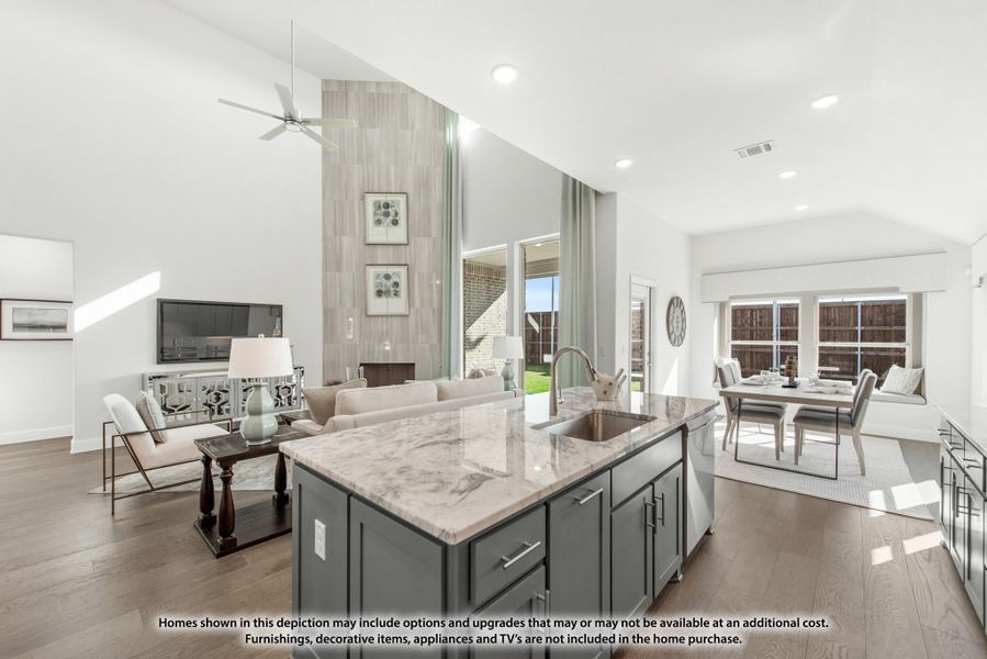 Open-concept living area with kitchen island, marble countertop, vaulted ceiling, and dining space visible in background Open-concept living area with kitchen island, marble countertop, vaulted ceiling, and dining space visible in background