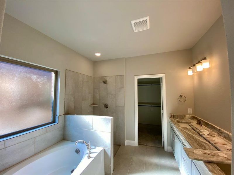 Master bathroom offers dual sinks in granite vanity, garden tub, shower, & 12x24 cermamic tile