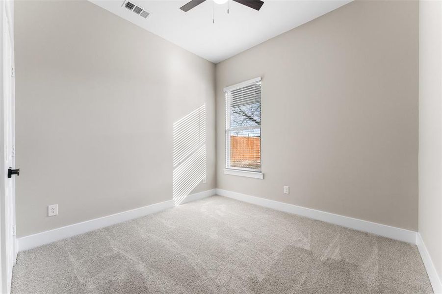 Carpeted spare room featuring ceiling fan