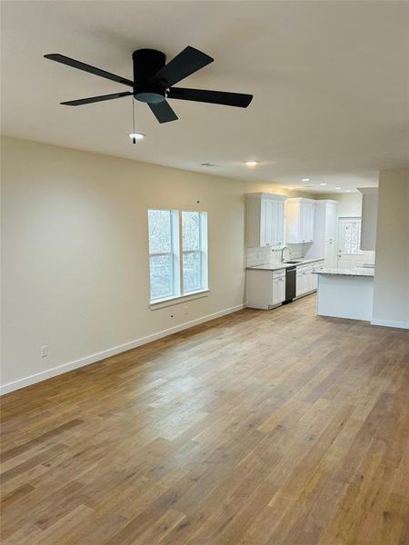 Living room with ceiling fan and light hardwood / wood-style flooring