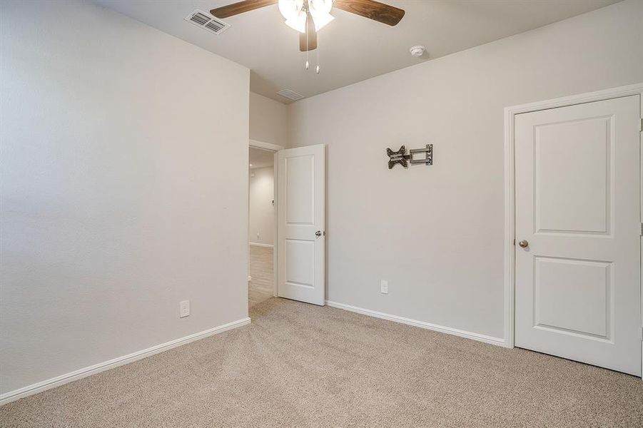 Unfurnished bedroom featuring carpet flooring and ceiling fan