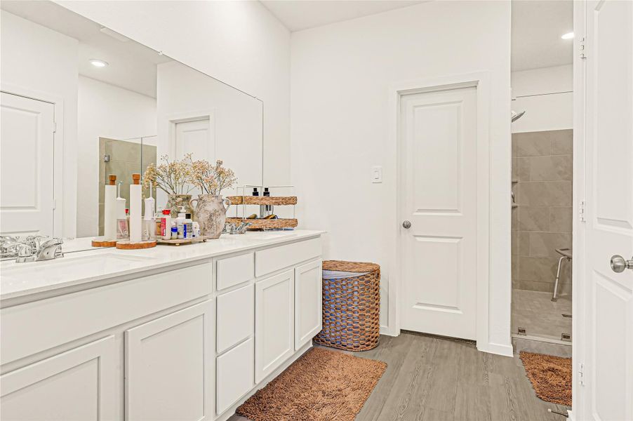 Bright and spacious bathroom featuring a double vanity with ample cabinet storage, elegant fixtures, and a modern shower area. Bright and spacious bathroom featuring a double vanity with ample cabinet storage, elegant fixtures, and a modern shower area.