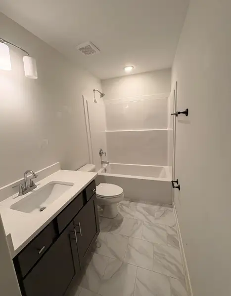 Full bathroom with vanity, bathtub / shower combination, and light marble finish flooring