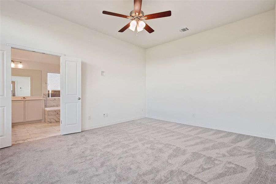 Empty room with light carpet and ceiling fan