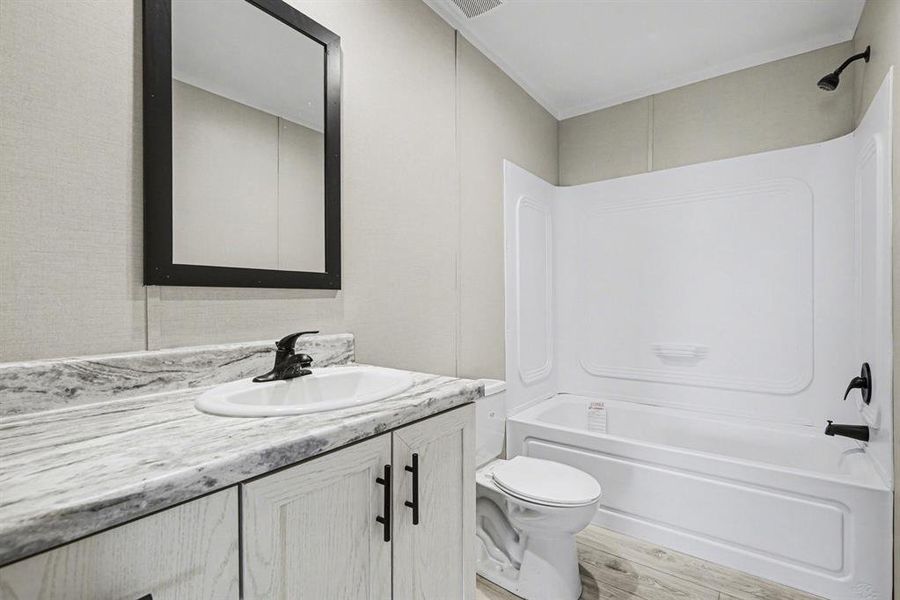 Full bathroom featuring a white vanity with a lovely countertop, integrated china sink, black framed mirror and matte black faucet - upgrades for an aesthetic you will love.