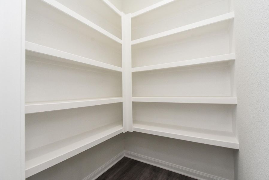 An empty corner closet with white shelves and grey flooring in a clean, modern interior. An empty corner closet with white shelves and grey flooring in a clean, modern interior.
