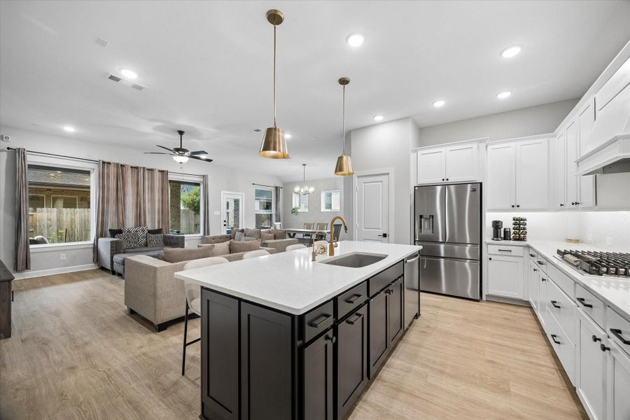The chef-inspired kitchen impresses with quartz countertops, custom cabinetry, pendant lighting, stainless steel appliances, a spacious center island with breakfast bar seating, and seamless flow into the main living areas. The chef-inspired kitchen impresses with quartz countertops, custom cabinetry, pendant lighting, stainless steel appliances, a spacious center island with breakfast bar seating, and seamless flow into the main living areas.