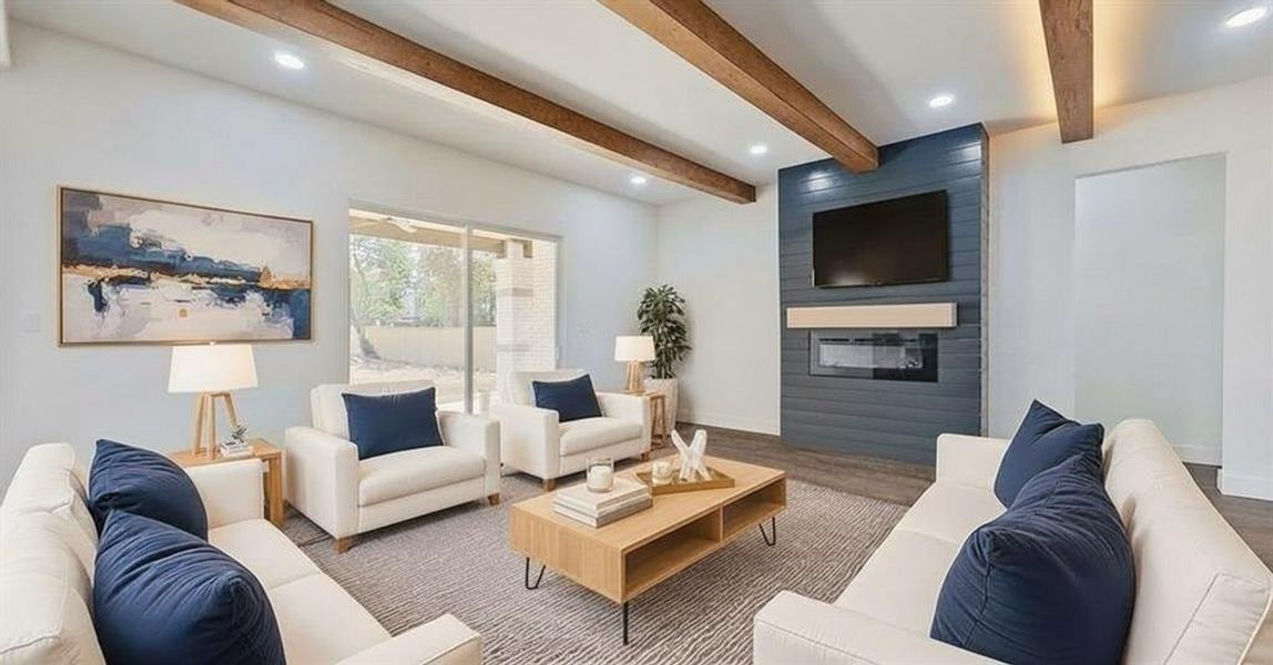 Living room with beamed ceiling, a fireplace, recessed lighting, and wood finished floors