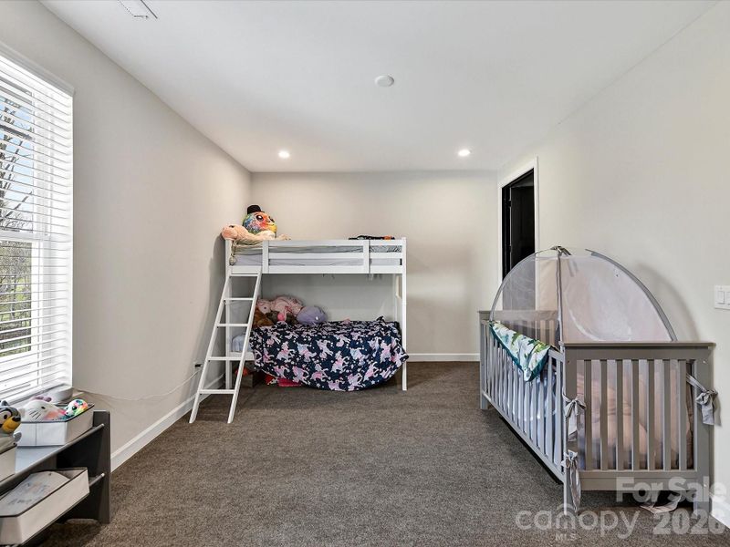 Spacious bedroom with plush carpeting & perfect for flexible family living.
