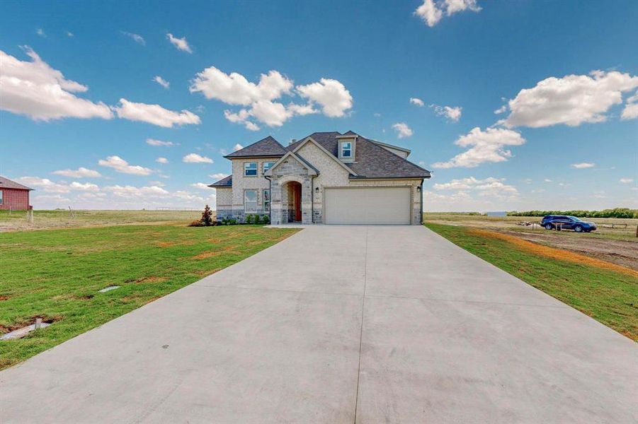 French country home with a rural view and a front yard