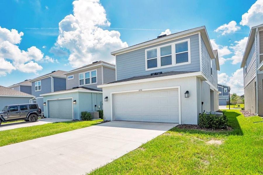 Front exterior of a new home in Wellness Ridge, Clermont, FL, highlighting curb appeal (Image 21).